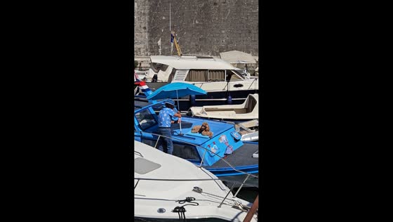 Owner sets up umbrella for lounging dog on boat in Zadar, Croatia