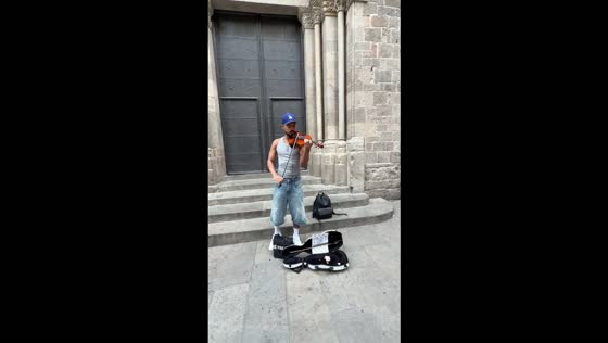 Street musician performs "Wicked Game" on violin outside Barcelona Cathedral in Spain