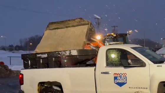 Road crews load salt spreader during snowfall in Rochester, New York, USA