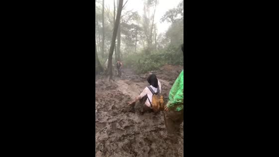  Hiker slides down muddy mountain slope in Java, Indonesia