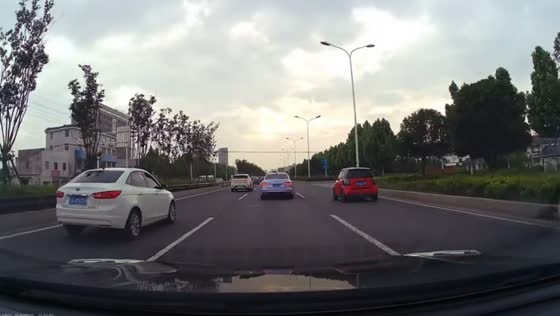 Car swerves into roadside gutter after sudden lane change in Nanjing, China