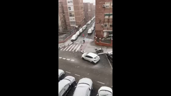 Light snowfall drifts through Ciudad Lineal neighborhood in Madrid, Spain