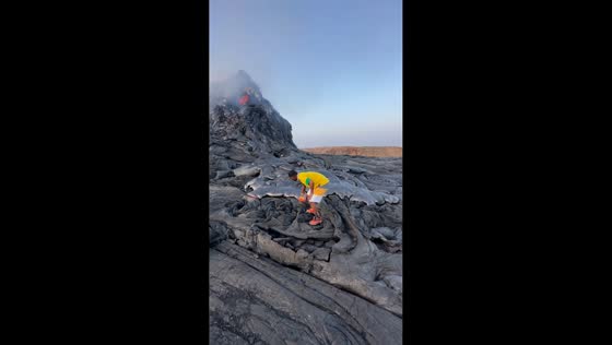 Traveler pokes molten lava as Erta Ale volcano erupts in Afar, Ethiopia
