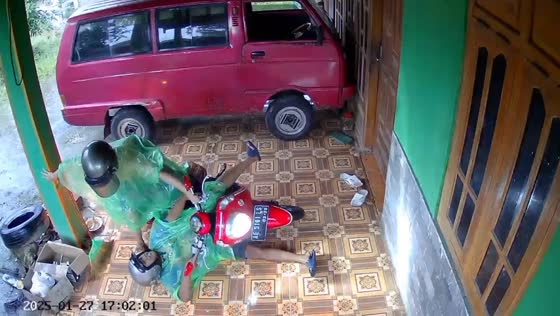 Woman slips while parking scooter in Ngawi, Indonesia