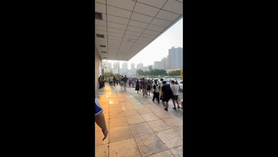 Two men lose their footing moments apart while walking with a crowd in Tianjin, China