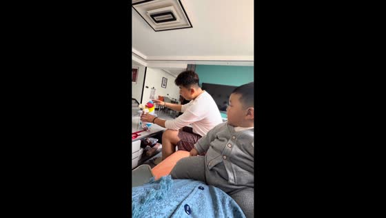 Father playfully entertains toddler with toy in Hebei, China