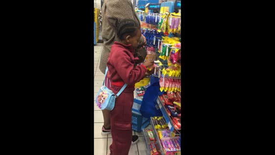 Little girl pretends to eat snack beside mom in Kariega, South Africa