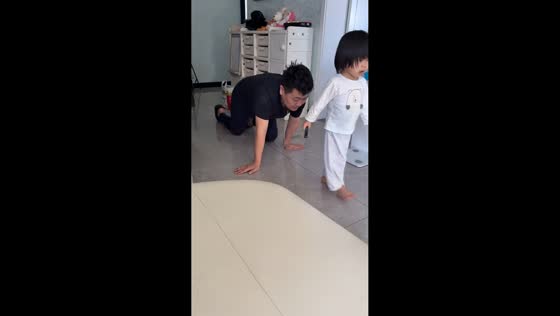 Playful father pretends to be a dog during family game in Hebei, China