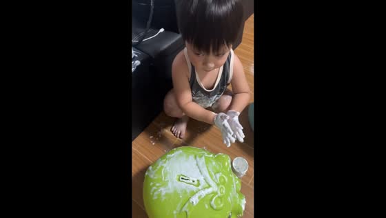 Toddler covers hands and piggy bank with Sudocrem in Batangas, Philippines