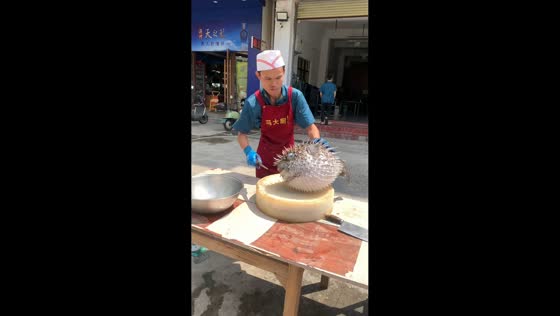 Chef prepares porcupinefish at outdoor stall in Hainan, China