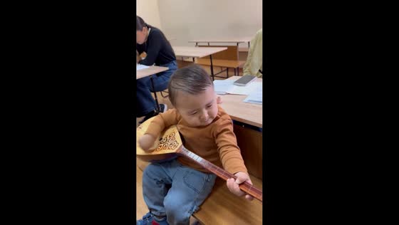Toddler explores traditional dombra in Almaty, Kazakhstan