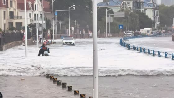 Delivery rider swept off scooter by storm surge in Qingdao, China