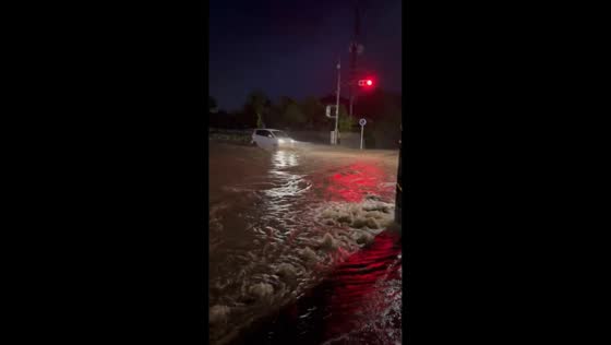 Vehicles struggle to navigate flooded road in Aira, Kagoshima