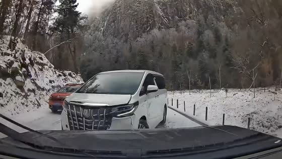 White car overtakes and crashes on slippery snowy road in Sichuan, China