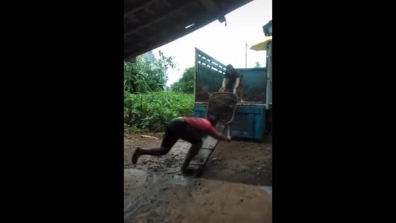 Man trips while pushing garden trolley in Lampung, Indonesia