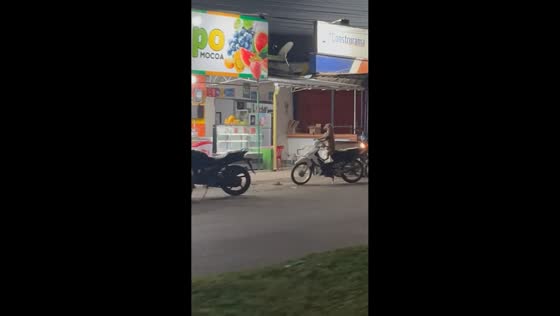Dog sits on parked motorcycle with paw on throttle in Mocoa, Colombia