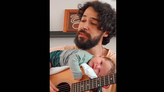 Father plays guitar as newborn enjoys the moment in Leuven, Belgium