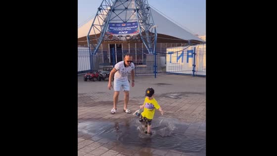 Joyful puddle escapade: a father's hilarious chase in Minsk