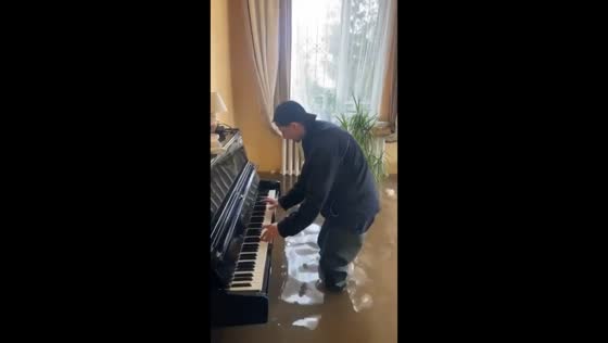 Piano performance amidst floods: Orenburg resident plays 'Csardas' in submerged home