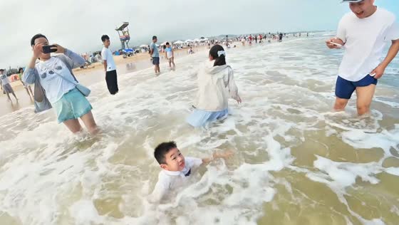 Boy loses balance as waves knock him into the water in Zhejiang, China