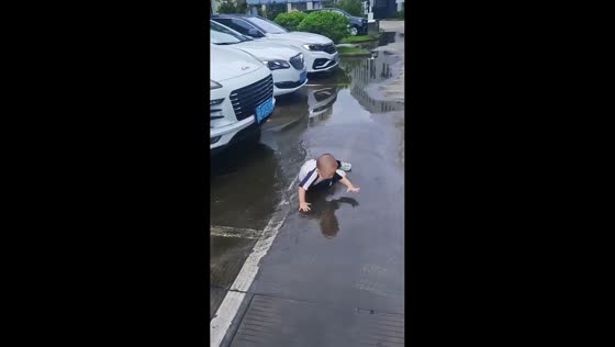 Little boy slips into a puddle while playing in Zhejiang, China
