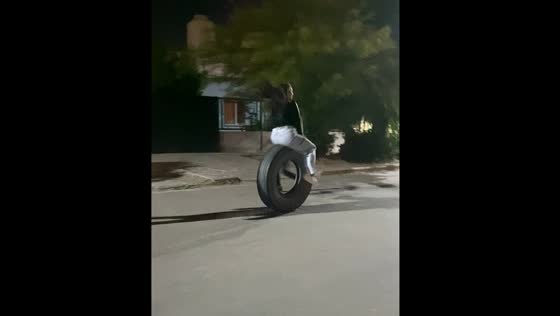 Women take turns riding a rolling tire in Trelew, Argentina