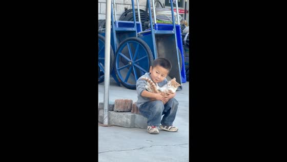 Boy cuddles a cat like a baby in Xinjiang, China