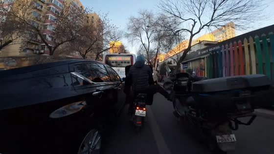Man kicks down motorcycle parked in the middle of the road in Beijing, China