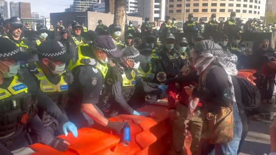 Pro-Palestine protesters blow bubbles as police form barricade in Melbourne