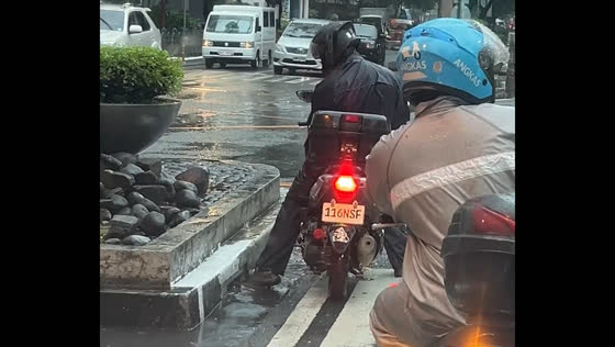 Motorcyclist attempts drainage clearance during stoplight in Makati