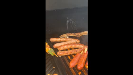 Grilled sausage squirts like a fountain in barbecue scene in Marseille, France