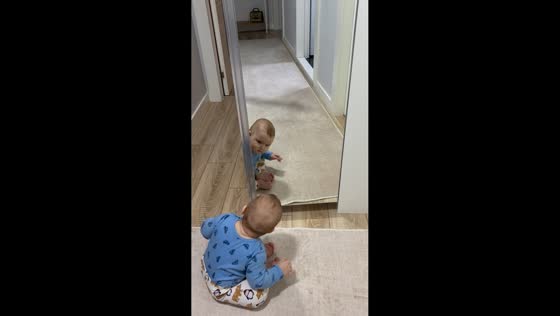 Baby delighted by own reflection in İzmir, Turkey