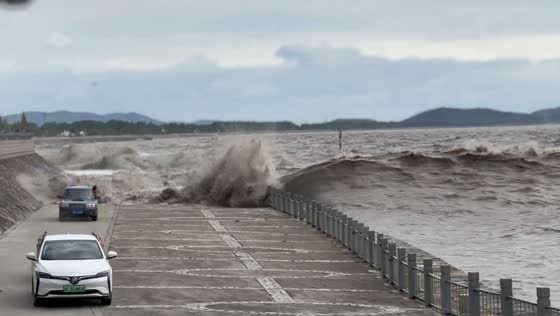 Tide chases cars by Qiantang River