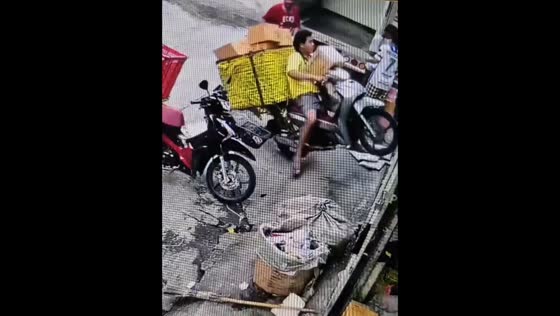 Motorcycle overturns but parcel breaks the fall in Bangkok, Thailand