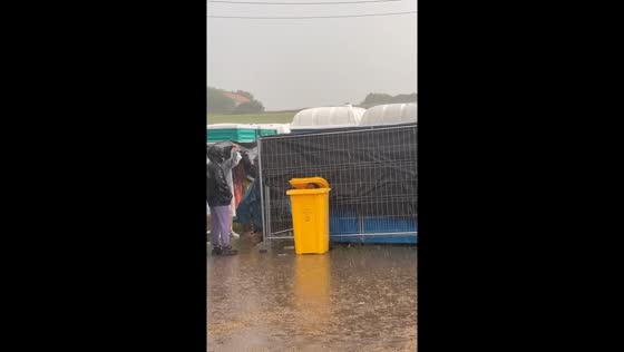 Person hides in trash bin to escape heavy rain at Negrita Music Festival, Spain