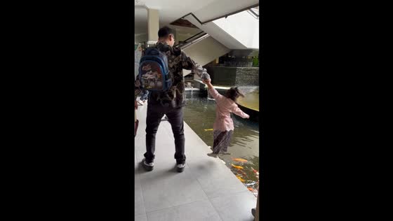 Little girl’s funny attempt to jump into koi pond in Hanmer Springs, New Zealand