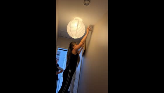 Woman carefully traps spider while standing on chair in Cormeilles-en-Parisis, France