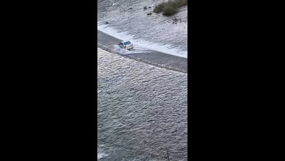 Vehicle navigates slippery Blangue Dam bridge safely in Sao Francisco de Paula, Brazil