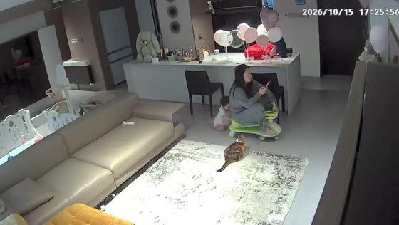 Toddler pushes mother around living room on a ride-on toy car in Hubei, China
