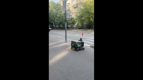 Yandex Rovers line up at roadside to cross pedestrian crossing in Moscow, Russia