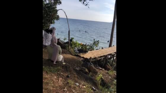 Person falls off ramp by the ocean during vacation video