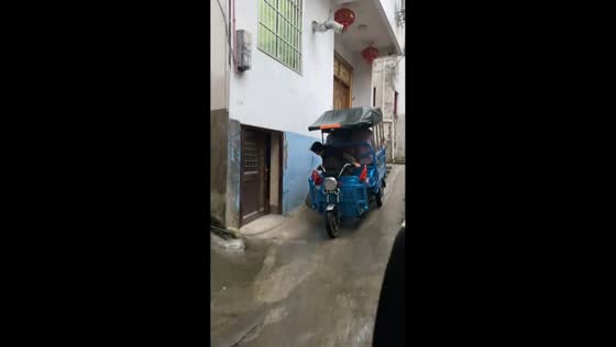 Skilled maneuver of electric 3-wheeler on narrow slope, Zhejiang, China