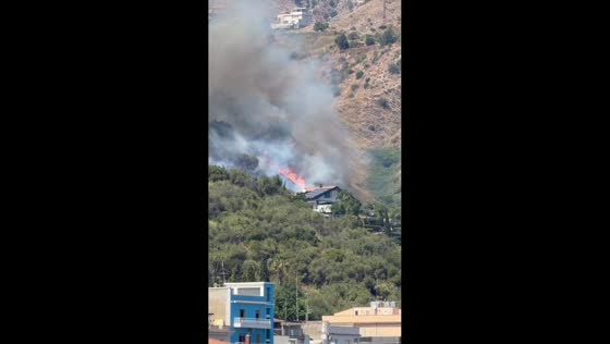 Wind-driven wildfire burns near homes in Giardini Naxos, Sicily, Italy