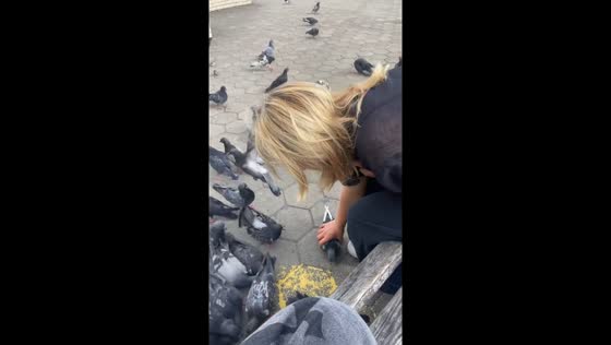 Woman gently places dove into her bag in Birobidzhan, Russia