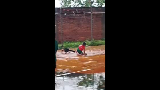 Boy crashes bicycle during rainy ride in El Puente, Bolivia