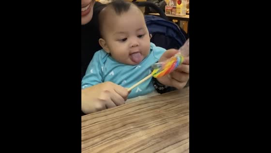 Sibling сandy struggle: big eyes and tears over a huge lollipop in Melaka, Malaysia