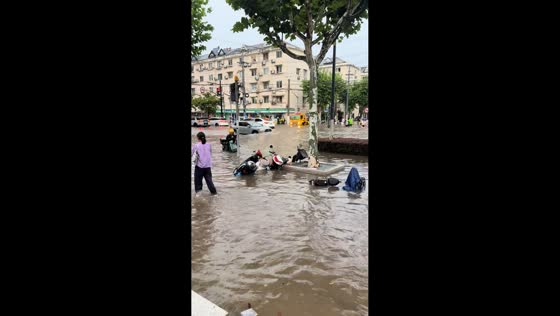 Flooded street leaves vehicles stranded near subway entrance in Shanghai, China