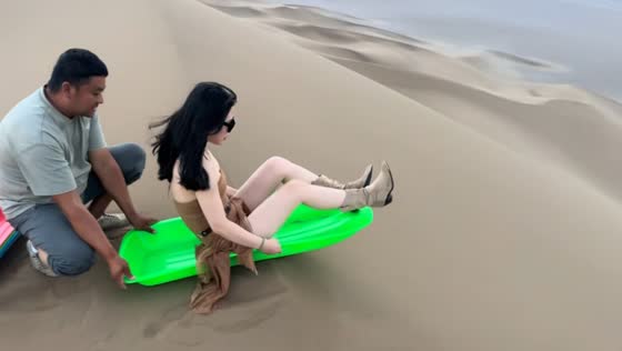 Woman enjoys thrilling sand dune slide in China