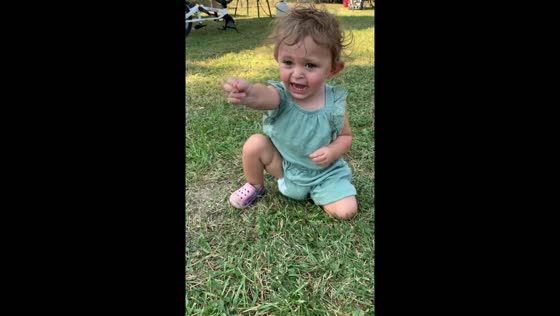 Child plays quietly in grass until asked about activity in Crown Point