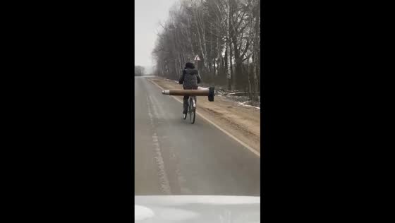 Cyclist transports large ammunition piece in Bryansk, Russia